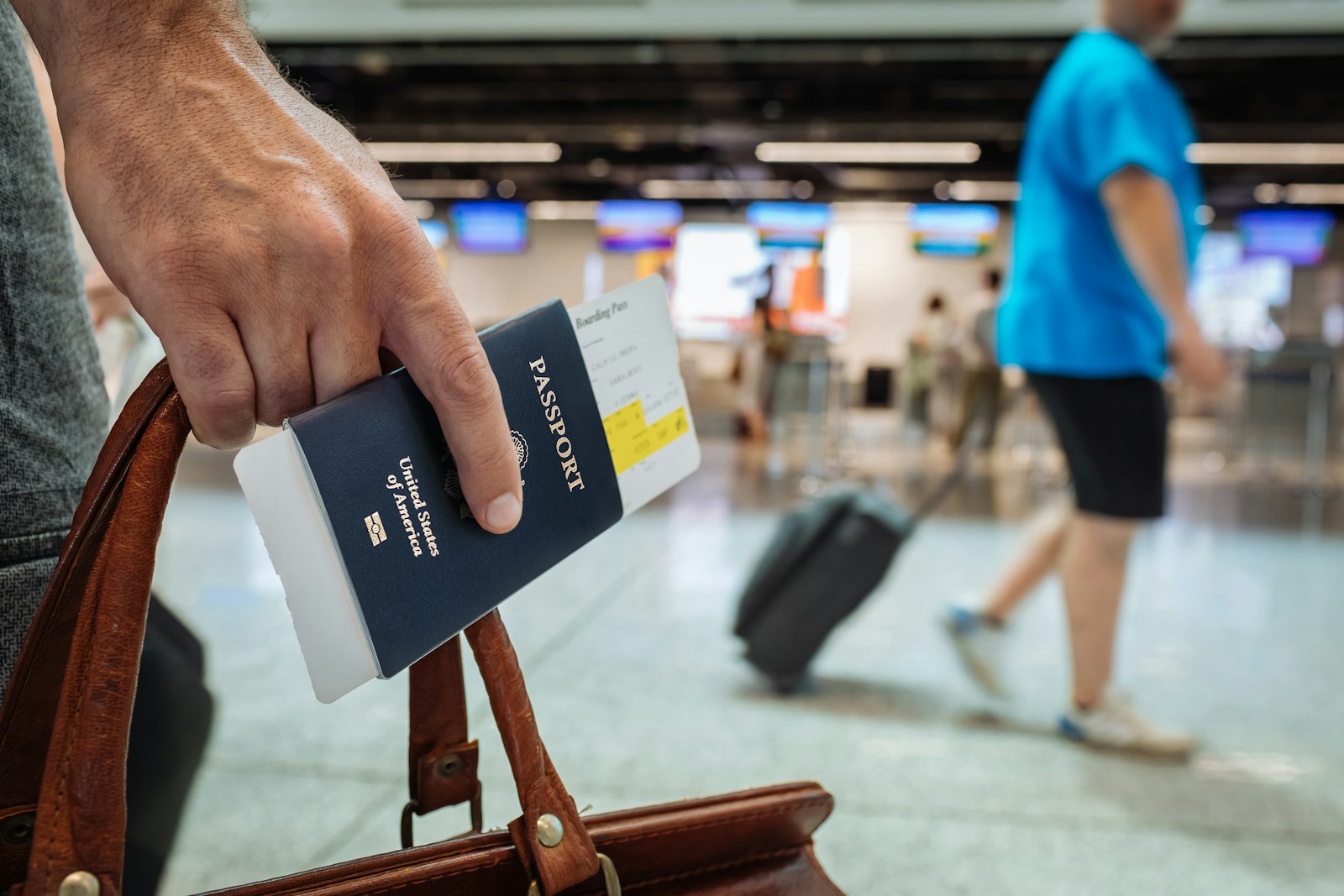 A traveller holding a passport and boarding pass at the airport