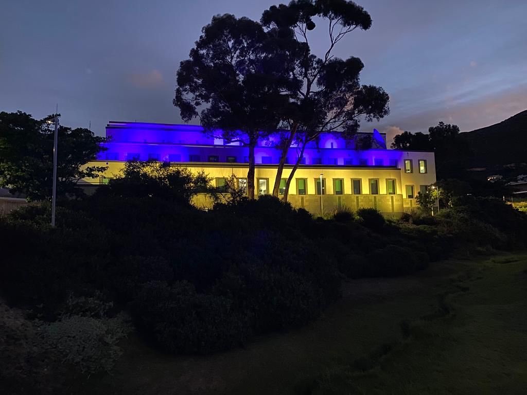 A U.S. consulate building lit in blue and yellow